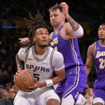 NBA 球星詹姆斯（LeBron James，23號）身穿湖人隊紫色球衣，在比賽中進行跳投，現場觀眾環繞，體現比賽焦點。