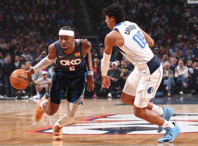 NBA雷霆队核心亚历山大（SGA）持球突破，与独行侠队球员进行防守对抗，体现亚历山大高效表现。