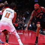 暴龍隊球員（3號）在 NBA 比賽中持球，面對尼克隊球員（11號Brunson）的防守