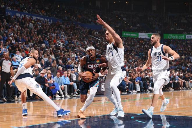 NBA比赛中雷霆队球员(2号球衣)在独行侠队多名球员的包夹下运球,体现雷霆队在比赛中的进攻压力。