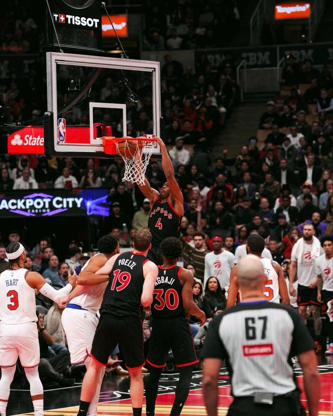 暴龍隊球員(4號)在 NBA 比賽中完成扣籃,尼克隊球員(3號 Hart)在籃下進行防守。