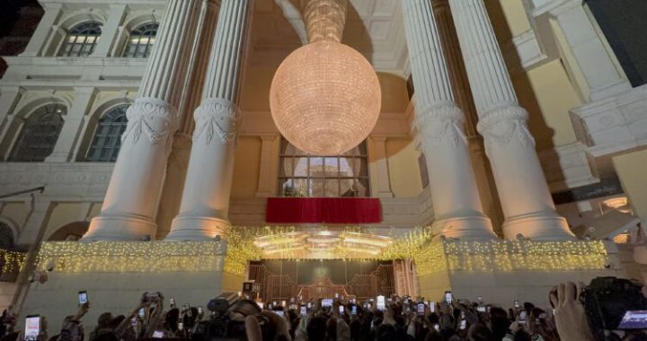 澳门十六浦赌场（Ponte 16）于 11 月 28 日正式停止运营，结束 17 年历史。图片展示了夜晚灯火通明的赌场外部，巨大的吊灯和古典立柱下，大量人群举起手机拍照记录这一历史性时刻。此图象征澳门卫星赌场重组背景下十六浦关闭的关键一步。