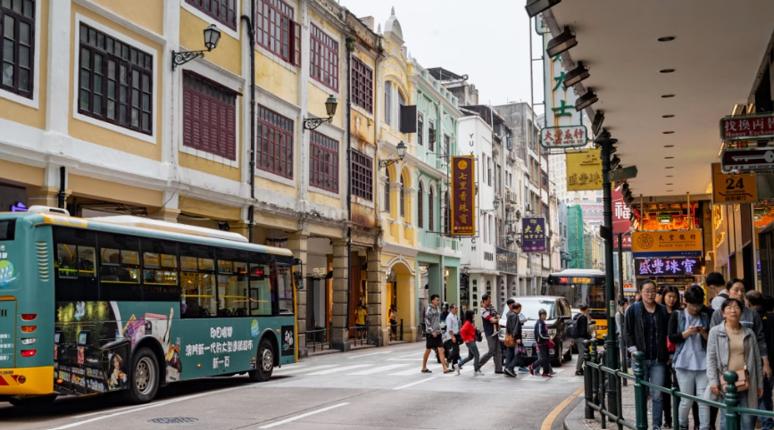 澳门街区人潮与巴士通行，游客到访量增长