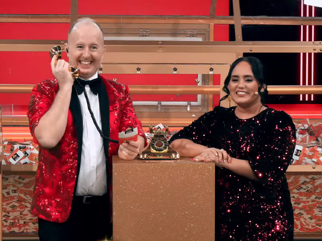 演播室主持人与女子展示抽奖电话道具与奖台