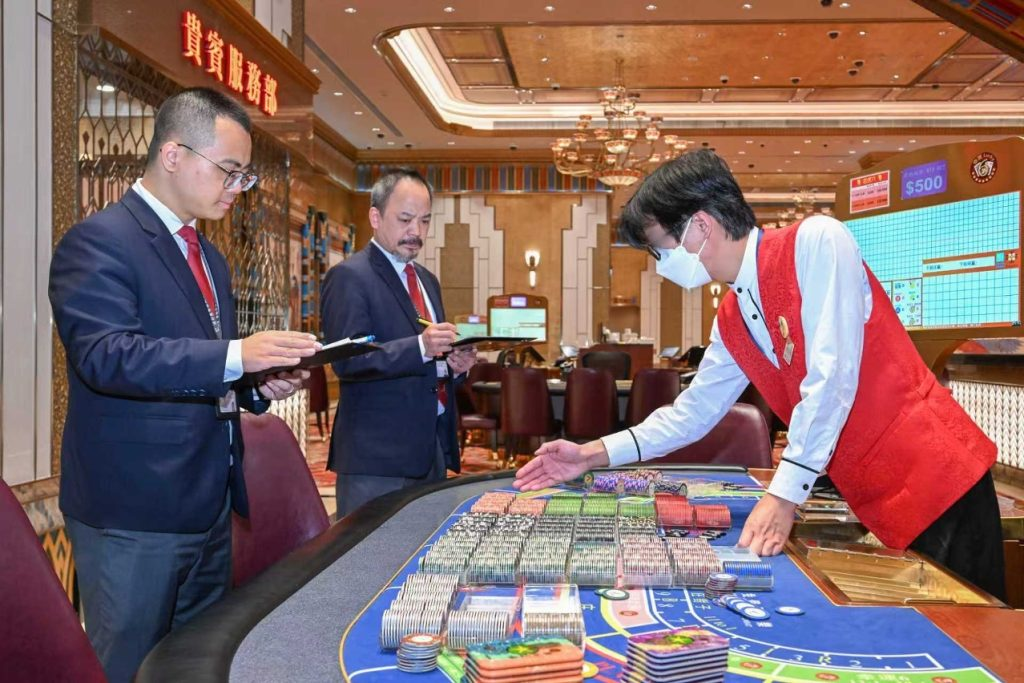 监管人员检查赌桌筹码，澳门卫星场置地结业