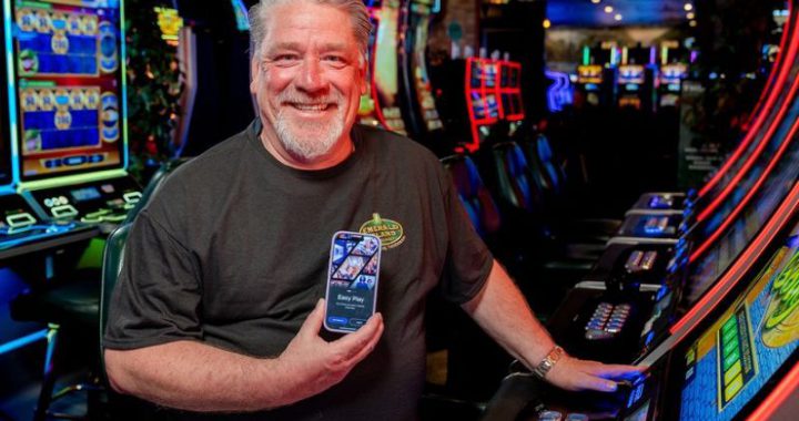 男子在老虎机区展示手机Koin应用，无现金支付话题