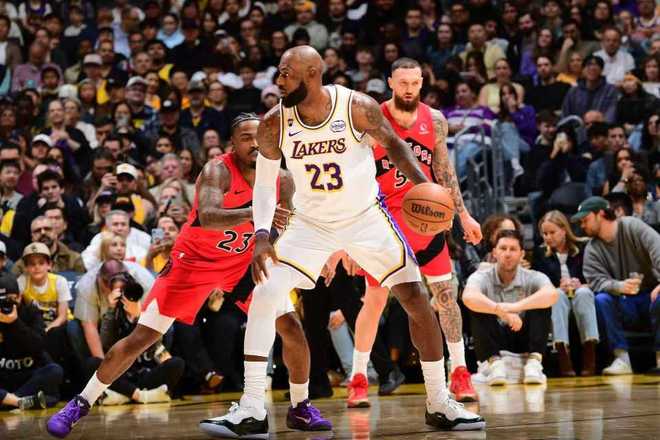 詹姆斯低位持球对抗猛龙防守，湖人主场胜利