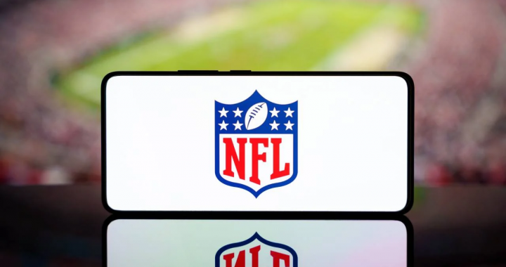 智能手机屏幕显示NFL标志与模糊球场背景