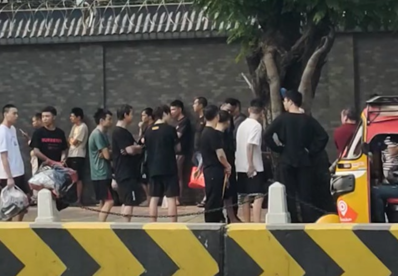 反诈骗行动后人员在使馆外等待证件协助