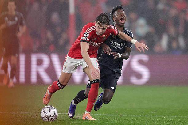 皇马与本菲卡球员雨中拼抢，欧冠比赛对抗瞬间