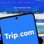 手机屏幕展示Trip.com标志，中国市场反垄断调查背景配图