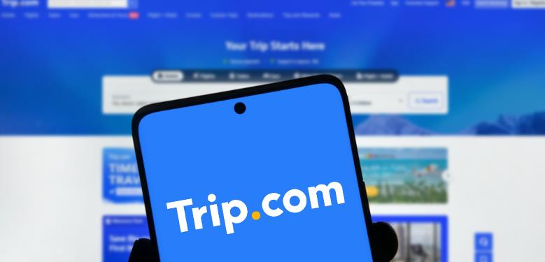 手机屏幕展示Trip.com标志，中国市场反垄断调查背景配图
