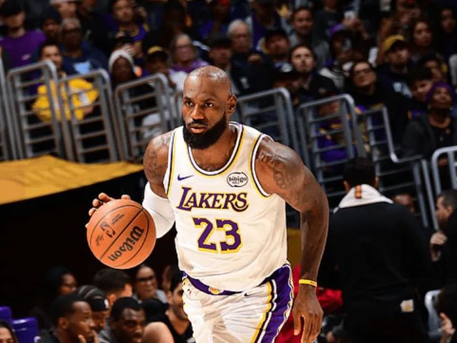 詹姆斯身穿湖人23号运球推进，主场观众席背景