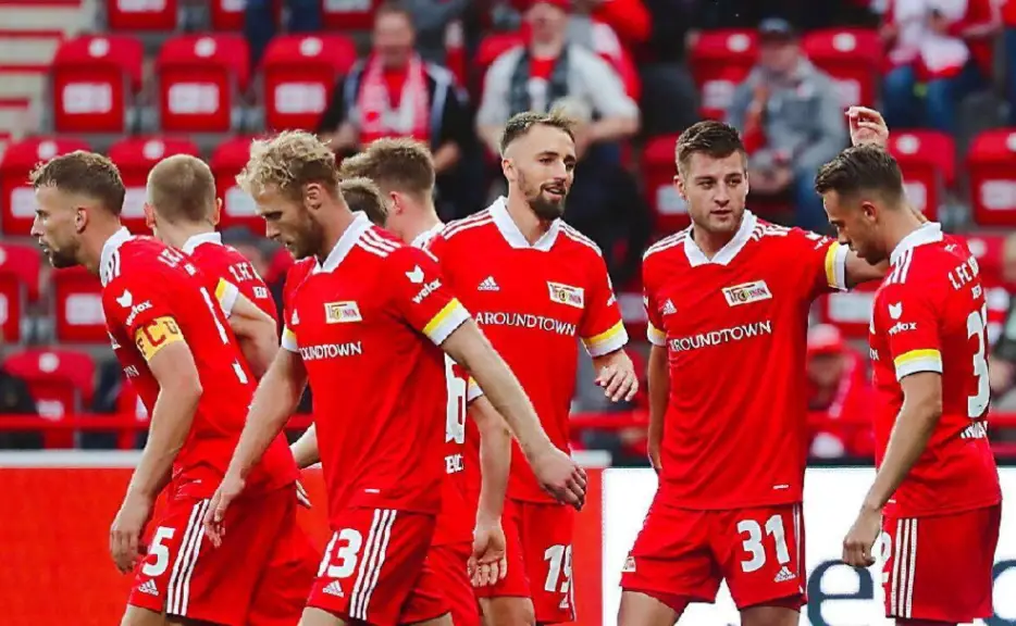 德甲赛场柏林联合球员围拢庆祝进球