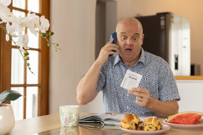 男子手持大奖支票激动表达中奖喜悦画面