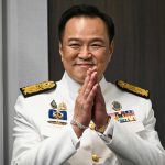 泰国总理阿努廷身着白色礼服双手合十致意画面