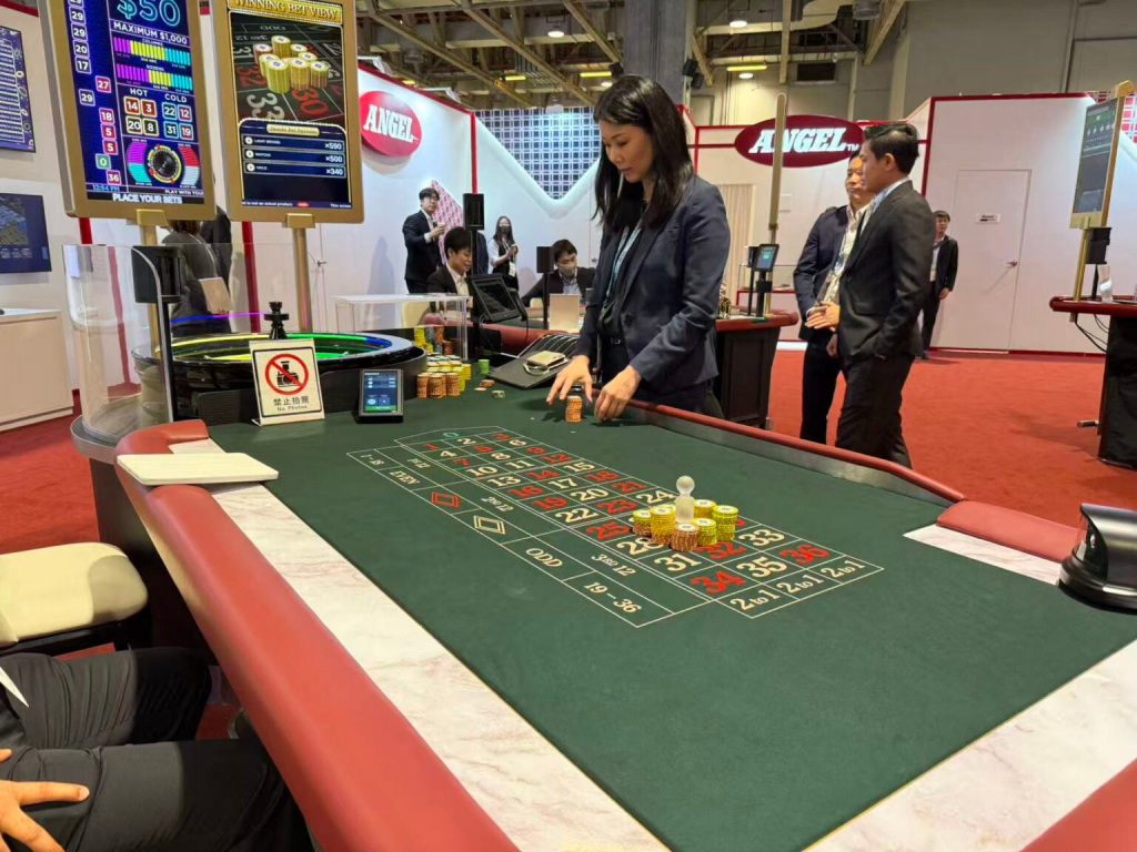 Angel在澳门G2E Asia展会展示智能轮盘赌枱技术，工作人员操作筹码与电子屏幕