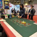 Angel在澳门G2E Asia展会展示智能轮盘赌枱技术，工作人员操作筹码与电子屏幕