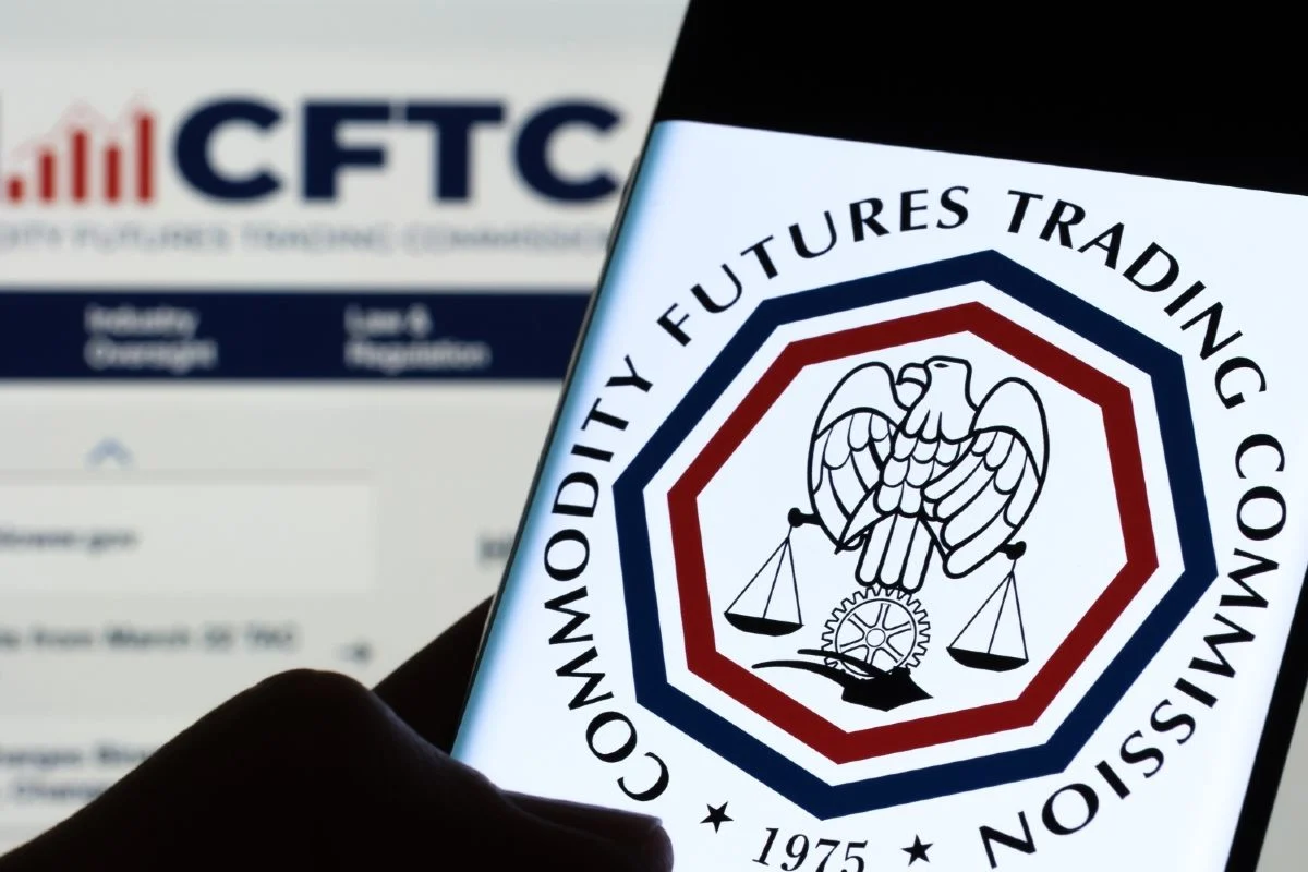 手机画面显示美国商品期货交易委员会CFTC标志，象征农业团体要求监管机构审查预测市场农产品事件合约