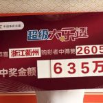 浙江衢州大乐透635万元中奖展示牌，中奖者手持第26054期超级大乐透大奖牌