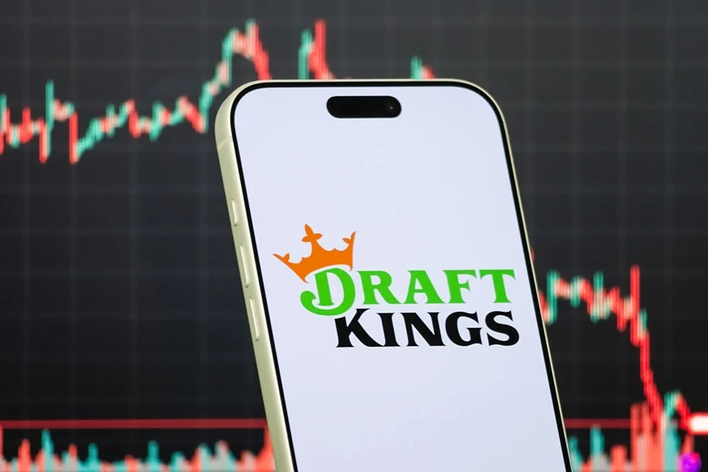 DraftKings手机应用标志与股票走势图背景，法国巴黎银行因预测市场威胁看空该股