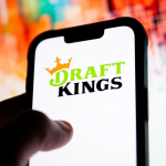 DraftKings标志显示在手机屏幕上，分析师看好其预测市场业务长期增长潜力