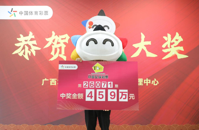 广西体彩中心兑奖现场，中奖者手持第26071期足彩459万元大奖奖牌