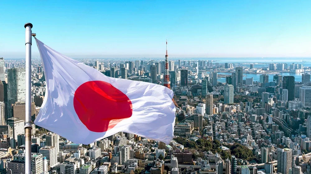 日本国旗飘扬在东京城市天际线前，象征日本预测市场与博彩监管环境