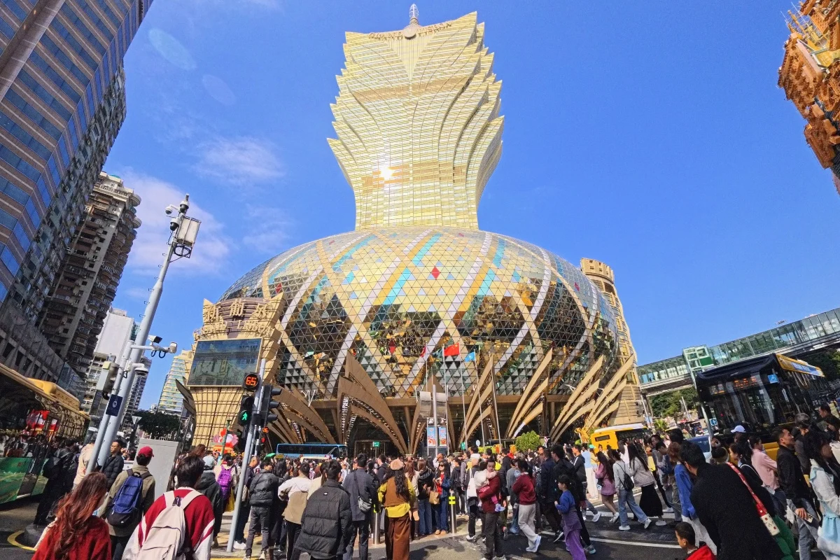 澳门新葡京酒店外观与游客人潮，展现澳门5月博彩收入增长和赌场股上涨背景