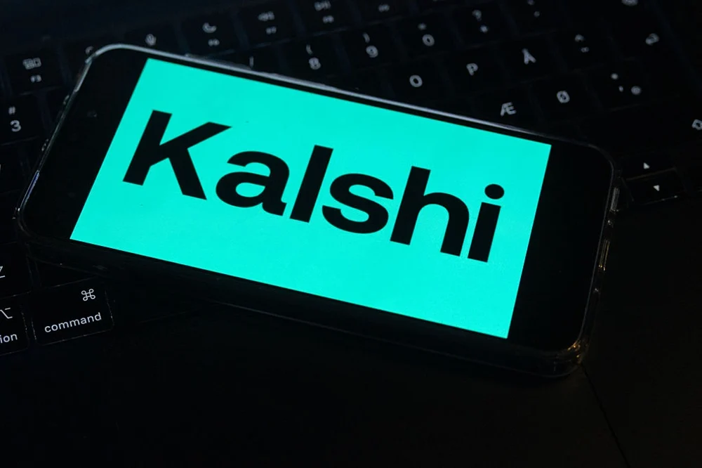 Kalshi标志显示在手机屏幕上，象征预测市场平台借世界杯提升品牌热度