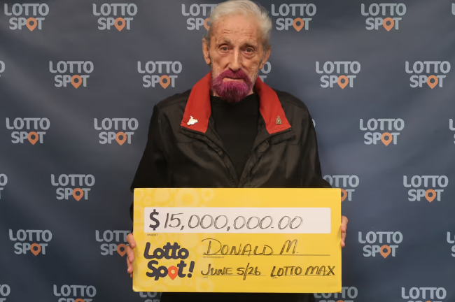加拿大Lotto Max 1500万加元大奖得主唐·马西森手持中奖彩票支票，展示标志性的粉红胡子
