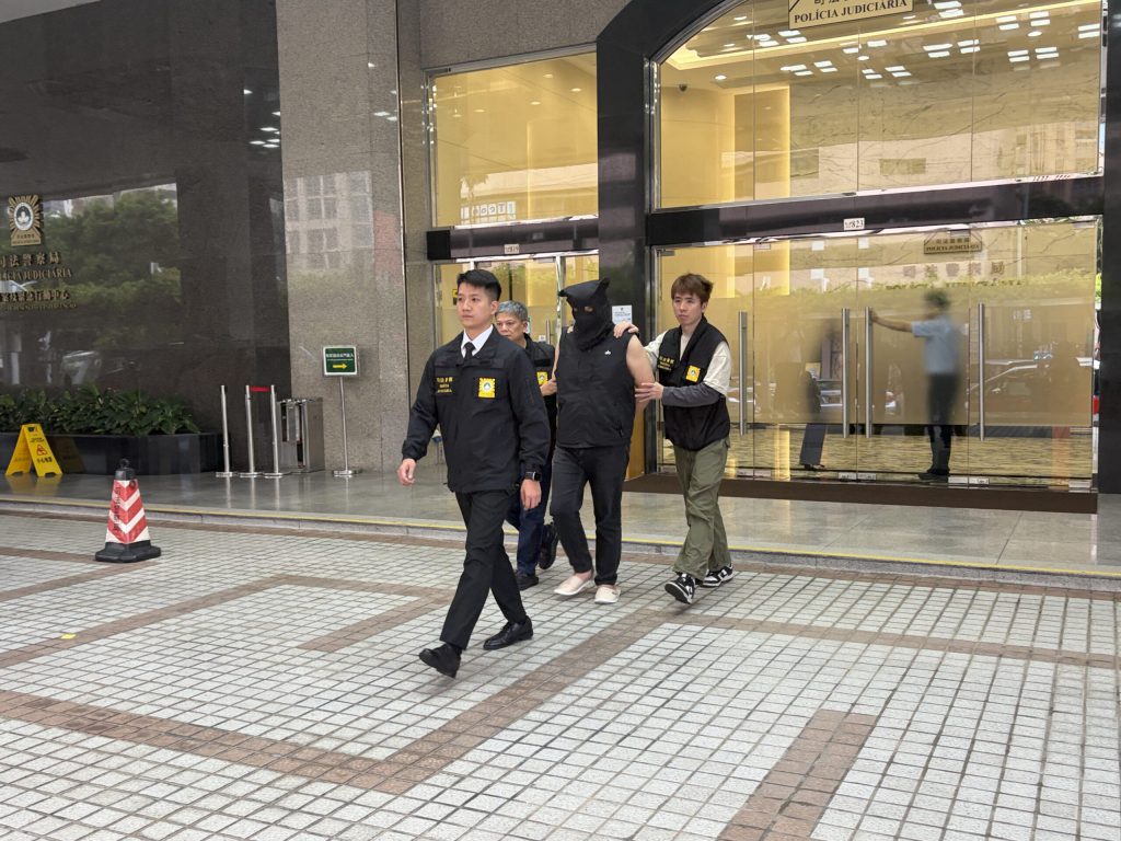 澳门司警人员将涉嫌非法直播赌局的男子带离司法警察局